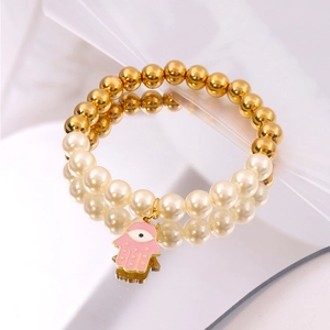 Dettaglio bracciale di perle con sfere dorate e ciondolo rosa mano di Fatima