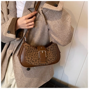 Détail du sac léopard avec garniture en cuir marron et boucle métallique sur un mannequin