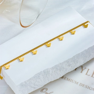 Elegant gold plated stainless steel butterfly charm anklet on a white stone display