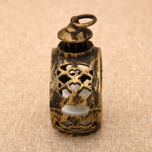 Close-up of vintage bronze LED lantern with hollow pattern on rustic linen fabric