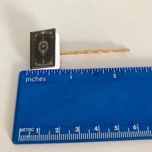 Miniature book hair clip with vintage gold pattern on gold barrette and size scale