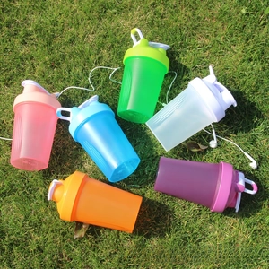 Detailed view of colorful portable sports shaker bottles on grass with carry handles