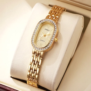 Detailed view of the gold oval dial with rhinestone bezel and roman numeral markers