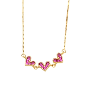 Detailed shot of gold-plated chain with three pavé-set pink heart-shaped pendants