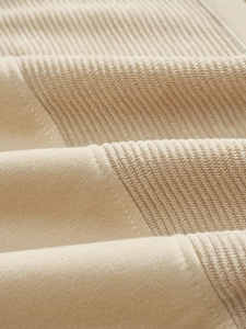 Macro shot of beige sweatshirt showing smooth knit fabric and ribbed texture stitching