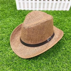 Detailed weave of a brown western straw cowboy hat with black leather band and metal buckle