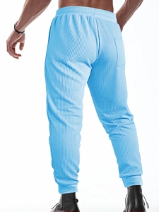 Detail shot of men's light blue waffle knit joggers showing back pocket and textured fabric