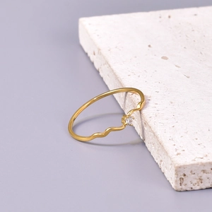 Minimalist gold wavy ring with single diamond setting on white travertine stone