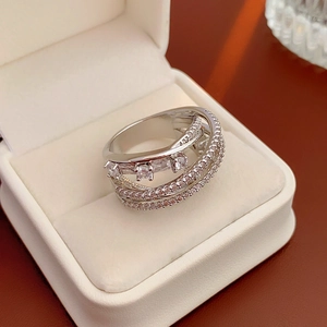 Detail shot of a silver layered ring with heart-shaped rhinestones in a jewelry box