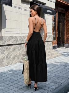 Elegantes schwarzes rückenfreies Maxikleid mit Stufenrock in der Rückansicht auf der Straße