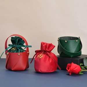 Detail of Christmas gift baskets in red and green leather with velvet drawstring liners