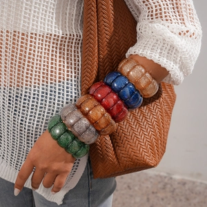 Chunky acrylic geometric bracelets with colorful glitter finish on a female model