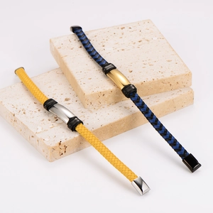 Braided leather bracelets with metal plates on beige travertine stone platforms