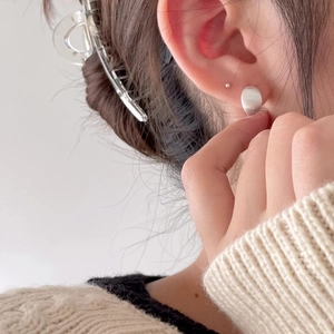 Close-up of matte 925 sterling silver geometric stud earring worn by model