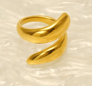 Close-up of polished 18k gold geometric spiral double-layer ring on beige silk