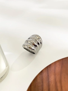Macro shot of silver ribbed croissant ring with polished multilayered metal texture