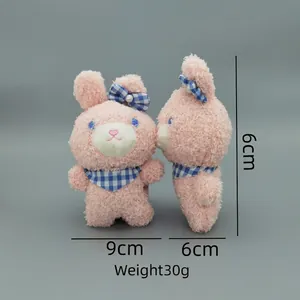 Pink plush rabbit charm with checkered bow, 9x6cm size display on gray background