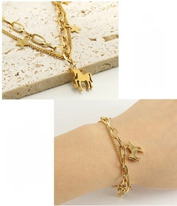 Détail d'un bracelet double couche en acier doré 18k avec pendentifs étoile et cheval