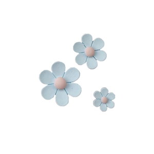 Close-up of three mini blue daisy magnets with pink centers for fridge or whiteboard