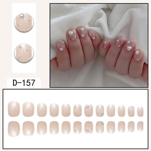 Faux ongles courts carrés rose nude avec perles blanches et petits clous argentés
