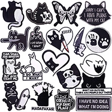 Detail of assorted black and white embroidered patches with edgy feline and ghost motifs