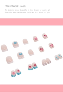 Detail of sweet press-on nails featuring red hearts, blue bows and silver glitter accents