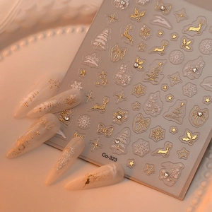 Detail of Christmas nail art stickers with gold and white reindeer and snowflake motifs