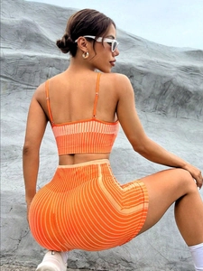 Dettaglio del set yoga arancione a costine con spalline sottili e pantaloncini a vita alta