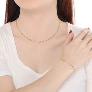 Vue détaillée d'un ensemble collier et bracelet maille serpent dorée avec petites perles