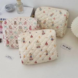 Vue détaillée de trois trousses à maquillage en coton matelassé avec ours et fleurs