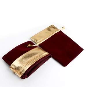 Close-up of wine red velvet drawstring pouches with gold trim and beaded cords