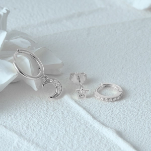 Macro shot of S925 sterling silver moon and star earrings set with sparkling crystals