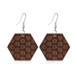 Detail of wooden hexagonal earrings with honeycomb pattern on a clean white background