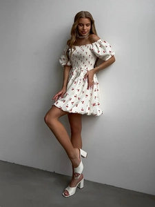 Detail of smocked bodice and puff sleeves on a white cherry print summer mini dress