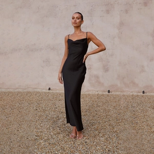 Elegant black satin maxi dress with deep V-neck shown in an outdoor setting