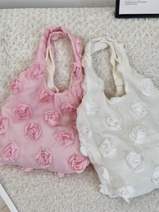 Pink and white tote bags with 3D floral rose design on plush surface for travel
