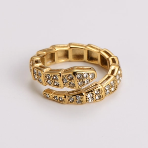 Macro shot of gold snake ring featuring white zircon stones and polished wrap-around design