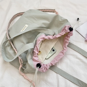 Detail der salbeigrünen Nylon-Tote-Bag mit rosa Innenfutter und Kordelzugverschluss