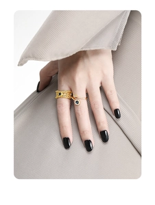 Close-up of golden crossover rings with blue zircon inlay on model hand