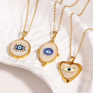 Detailed macro shot of three gold evil eye pendants on a white textured tray