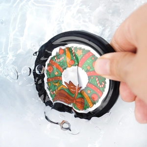 Close-up of waterproof Christmas wreath sticker showing splash resistance in water