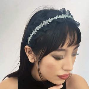Close-up of black mesh pleated headband with sparkling silver rhinestones on a model