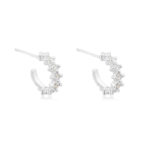 Detailed close-up of C-shaped silver earrings with sparkling cubic zirconia inlay