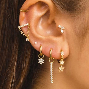 Detailed view of S925 sterling silver butterfly ear studs and gold tassel chains worn on model
