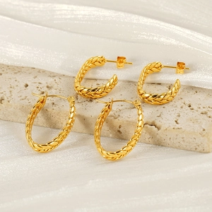 Vintage golden wheat-textured earring set on elegant stone and silk background