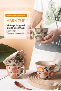 Macro detail of hand-painted floral ceramic mug with thick pottery texture and handle