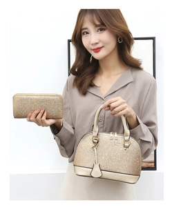 Detail view of shimmering gold sequin shell handbag and matching wallet with metallic handles