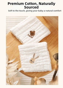 Detail of white cotton baby gauze towels with cute bear and rabbit embroidery