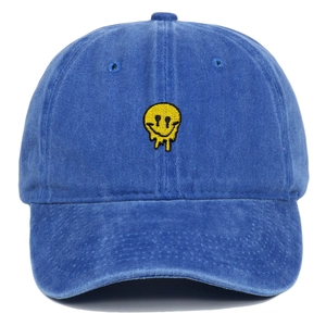 Close-up of melting yellow smiley face embroidery on a blue washed cotton baseball cap