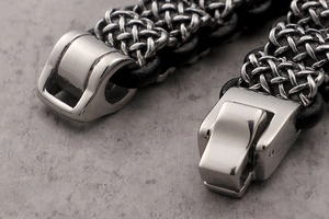 Macro shot of industrial stainless steel clasp and woven black leather strap on a men's bracelet